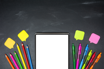 Digital tablet with blank transparent screen and school supplies on blackboard background, top view, copy space. E-learning concept