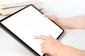 Child's hands holding digital tablet and touching blank transparent screen, e-learning concept