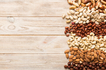 different nuts frame background. Close up, top view, flat lay with vopy space. Walnut, pistachios, almonds, hazelnuts and cashews