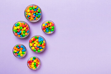 different colored round candy in bowl and jars. Top view of large variety sweets and candies with copy space