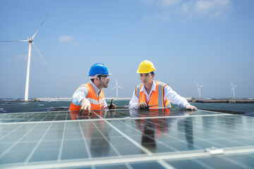 Solar and wind farm renewable energy. Foreman and Worker maintaining solar energy panel.