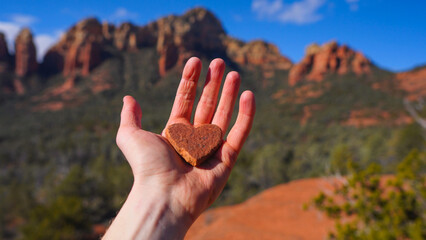 Hand holding heart shaped rock in Sedona, Arizona