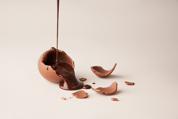 Crushed Brown Chocolate egg with liquid chocolate pour on white background