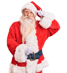 Old senior man with grey hair and long beard wearing traditional santa claus costume shooting and killing oneself pointing hand and fingers to head like gun, suicide gesture.
