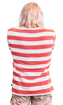 Old senior man with grey hair and long beard wearing striped tshirt standing backwards looking away with crossed arms