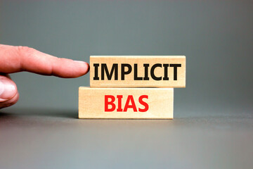 Implicit bias symbol. Concept words Implicit bias on wooden block. Beautiful grey table grey...
