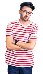 Young hispanic man wearing casual clothes shaking and freezing for winter cold with sad and shock...