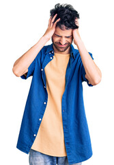 Young hispanic man wearing casual clothes suffering from headache desperate and stressed because pain and migraine. hands on head.