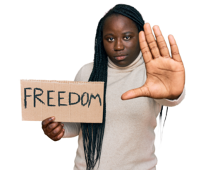Young black woman with braids holding freedom banner with open hand doing stop sign with serious and confident expression, defense gesture