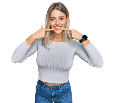 Beautiful blonde woman wearing casual clothes smiling cheerful showing and pointing with fingers teeth and mouth. dental health concept.