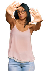 Obraz na płótnie Canvas Young african american woman wearing casual clothes and glasses doing frame using hands palms and fingers, camera perspective
