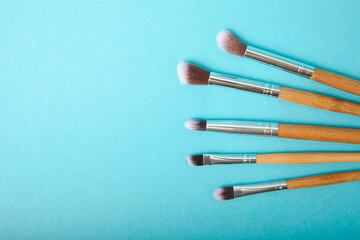 Set of cosmetic brushes on a blue background. Makeup brushes. Makeup tool. Beauty concept.Professional brushes for applying cosmetics eyeshadows, make-up powder. Place for text. Copy space. Flat lay.