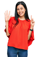 Beautiful young woman wearing casual clothes showing and pointing up with fingers number six while smiling confident and happy.