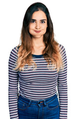Beautiful hispanic woman wearing casual striped shirt puffing cheeks with funny face. mouth inflated with air, crazy expression.