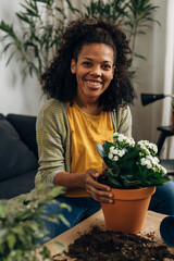 Smiling woman is proud of her houseplants