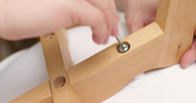 Self-assembly furniture concept. The young man himself assembling chairs