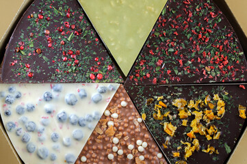 Original chocolate segments with various additives and spices. High angle view, selective focus, daylight