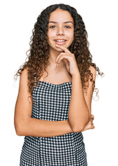 Teenager hispanic girl wearing casual clothes looking confident at the camera with smile with crossed arms and hand raised on chin. thinking positive.