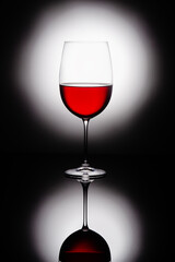 Naklejka na ściany i meble a glass of red wine on a dark background