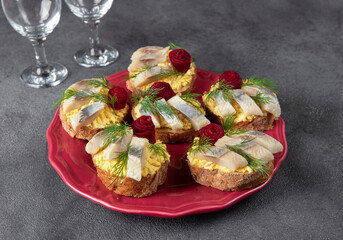 Homemade sandwiches with salted herring, cheese and egg, decorated with beetroot rose on plate