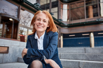 Confident middle-aged businesswoman, taking a well-deserved break from the urban business world, embracing the freedom and fresh air outside.