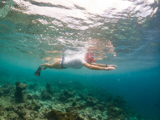 woman snorkeling in clear tropical sea