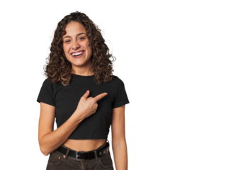 Radiant young woman with stunning curls smiling and pointing aside, showing something at blank space.