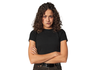 Radiant young woman with stunning curls frowning face in displeasure, keeps arms folded.