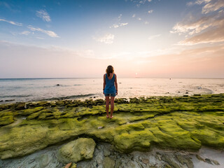 woman on a tropical beach at sunset