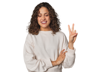Radiant young woman with stunning curls showing number two with fingers.
