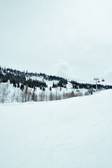 ski resort Goderdzi, Georgia. mountains are covered with snow. Red cable car above and mountains behind  - Image
