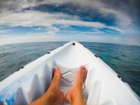 feet in a kayak on tropical sea
