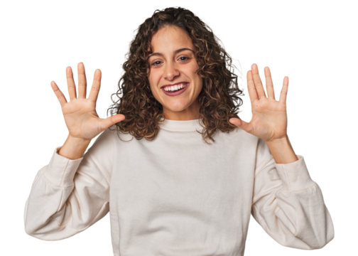 Radiant young woman with stunning curls showing number ten with hands.
