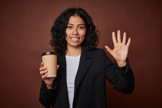 Young business woman drinking a take-away coffee smiling cheerful showing number five with fingers.