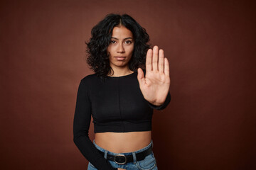 Young colombian curly hair woman isolated on brown background standing with outstretched hand...