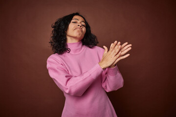 Young colombian curly hair woman isolated on brown background feeling energetic and comfortable,...