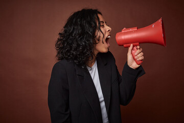 A young business woman passionately advocates for her rights with a megaphone.