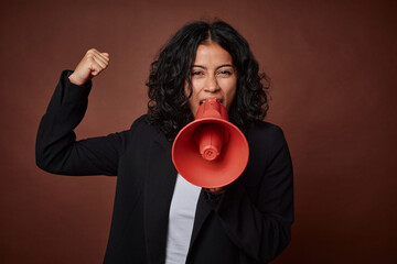 A young business woman passionately advocates for her rights with a megaphone.