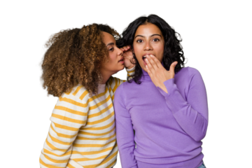 Two female friends isolated in studio is saying a secret hot braking news and looking aside