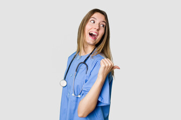 Young female nurse in uniform with stethoscope, symbol of care and dedication to patients points...