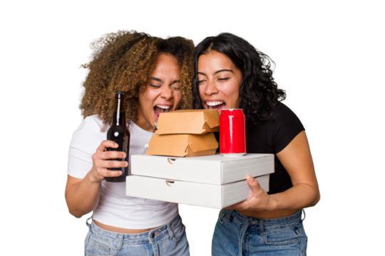 Two young women, one Latina and one with Afro hair, laugh as they hold pizzas and burgers from a recent delivery. 