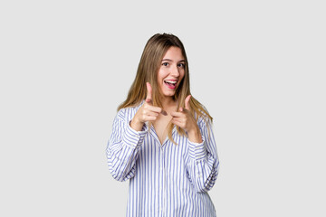 Young blonde posing for a portrait isolated, exuding natural beauty and radiance pointing to front...