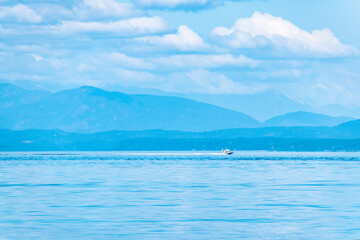 Boat  With Tropical Mountains on Summer Day Along Strait of Georgia in Vancouver Island, British Columbia, Canada