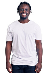 Young african american man with braids wearing casual white tshirt with a happy and cool smile on face. lucky person.