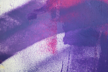 Messy paint strokes and smudges on an old painted wall with graffiti. Colorful drips, flows, streaks of paint and paint sprays
