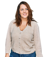 Young plus size woman wearing casual clothes looking away to side with smile on face, natural...