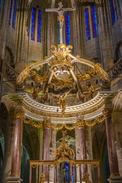 Nave of church in Brittany France with gold sculpture of angel hanging below white dove.