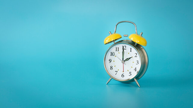Retro silver alarm clock.  2:00, am, pm. Blue background.