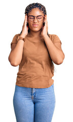 Young african american woman with braids wearing casual clothes and glasses suffering from headache desperate and stressed because pain and migraine. hands on head.