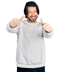 Middle age caucasian man wearing casual clothes approving doing positive gesture with hand, thumbs up smiling and happy for success. winner gesture.